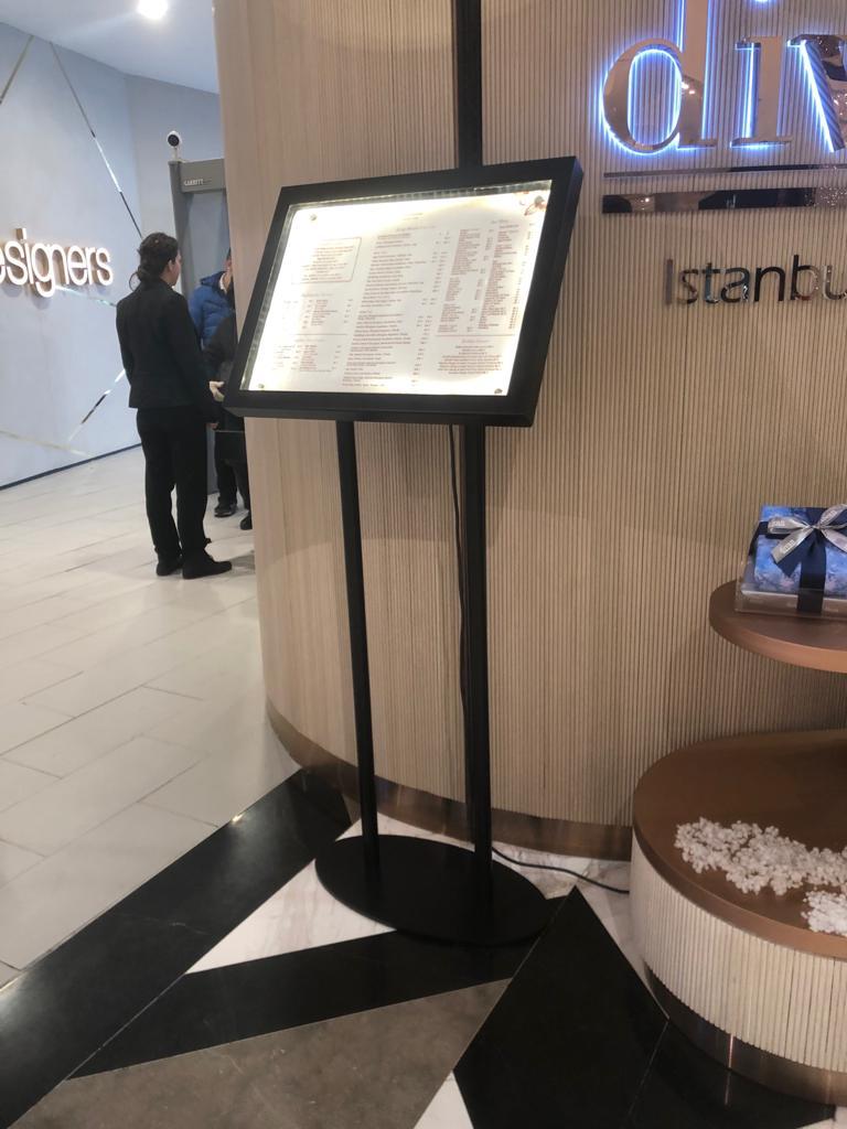 Işıklı Ayaklı Menü Panosu, şık tasarımıyla restoran ve kafeler için modern bir görünüm sunar. A3 boyutundaki menüler için uygun olup, LED aydınlatması sayesinde içerik loş ortamlarda bile net bir şekilde okunur.