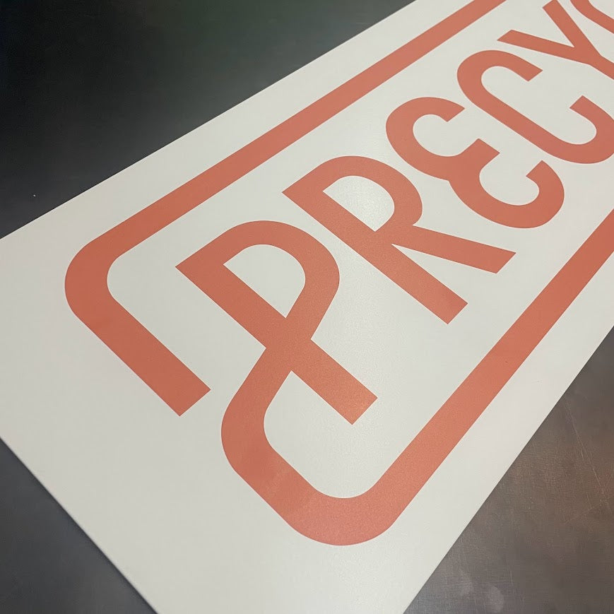 Yakın bakış açısıyla baskı detayları gösterilen metal tabela.