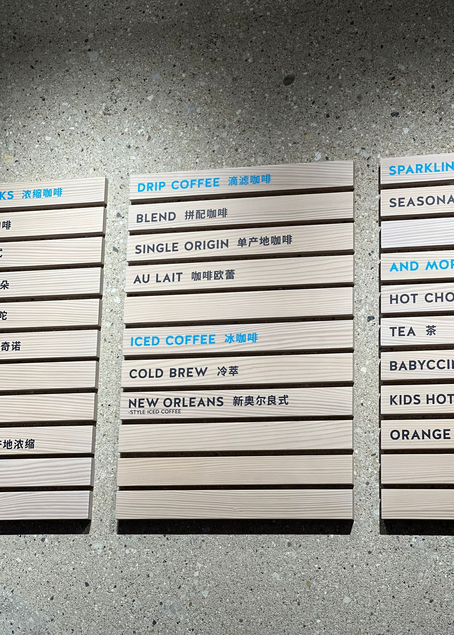 Kafe iç mekanda duvara sabitlenmiş ahşap fiyat listesi panosu