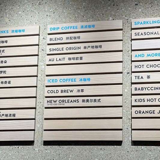 Duvara monte edilmiş ahşap menü tabelası, kafe duvarında sergileniyor