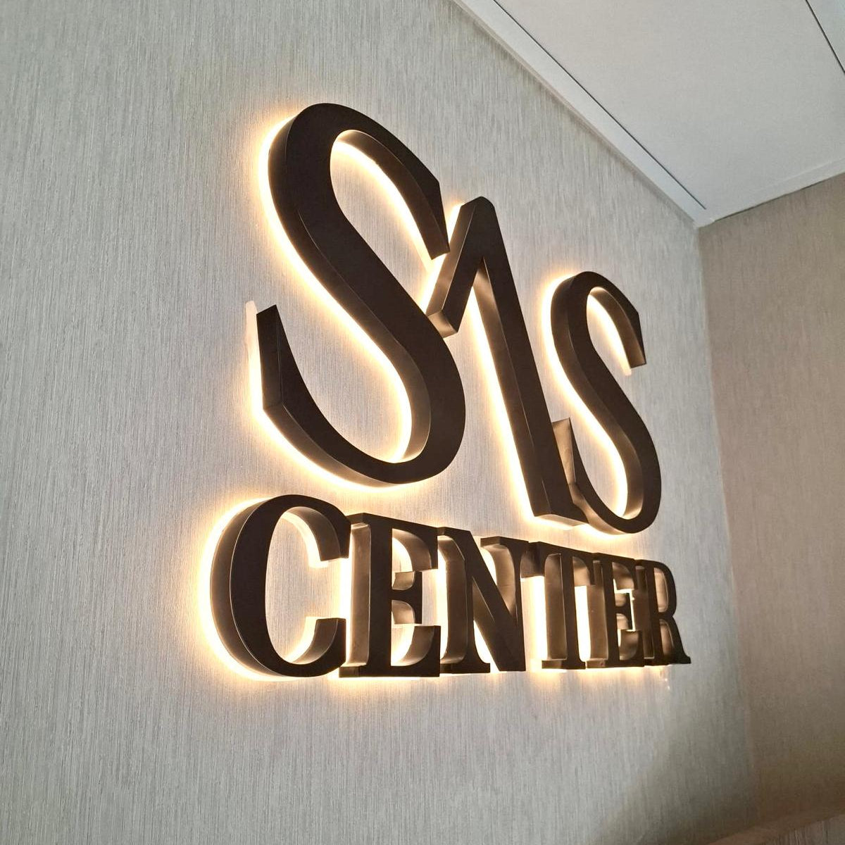 Duvara tek tek monte edilen arkadan LED aydınlatmalı üç boyutlu logo tabela