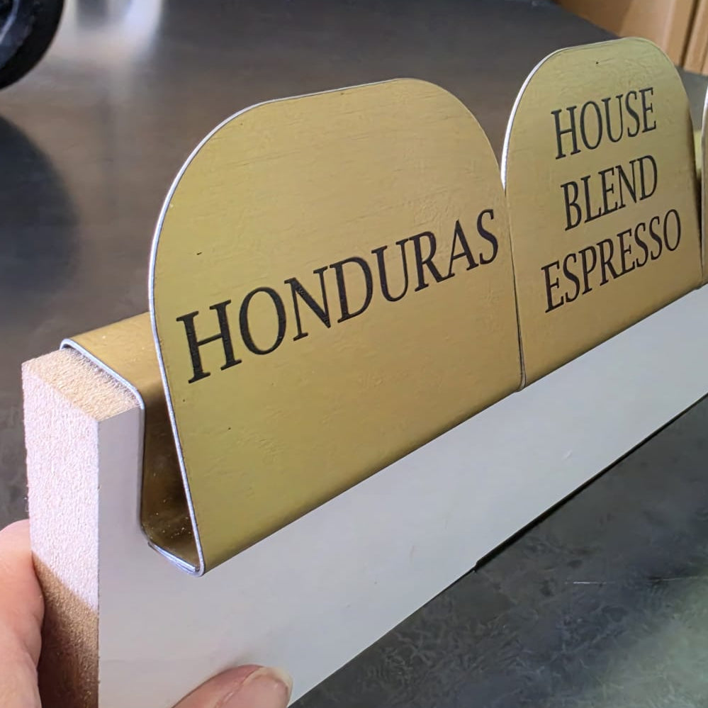 Barista istasyonunda kahve çekirdeği çeşitlerini tanıtmak için gold metal isimlik