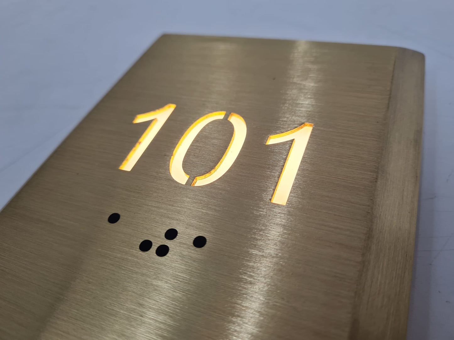 Otel oda numarası tabelası üzerindeki Braille alfabe uygulamasının yakın görünümü