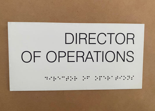 Braille alfabesiyle hazırlanmış otel ve ofis kapı isimliği, beyaz kabartma harflerle erişilebilir tasarım.