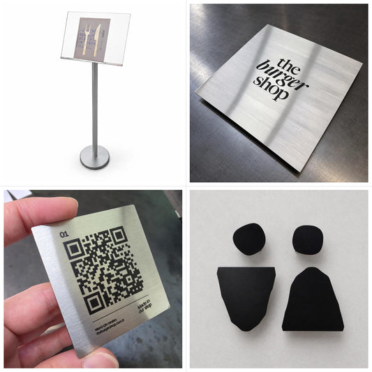 Burger restoran tabela setinin dört ürün grubu birlikte: gümüş ayaklı menü standı, paslanmaz giriş tabelası, QR menü plakası ve kadın–erkek WC işaretleri; QR plakaları set içinde 30 adettir.