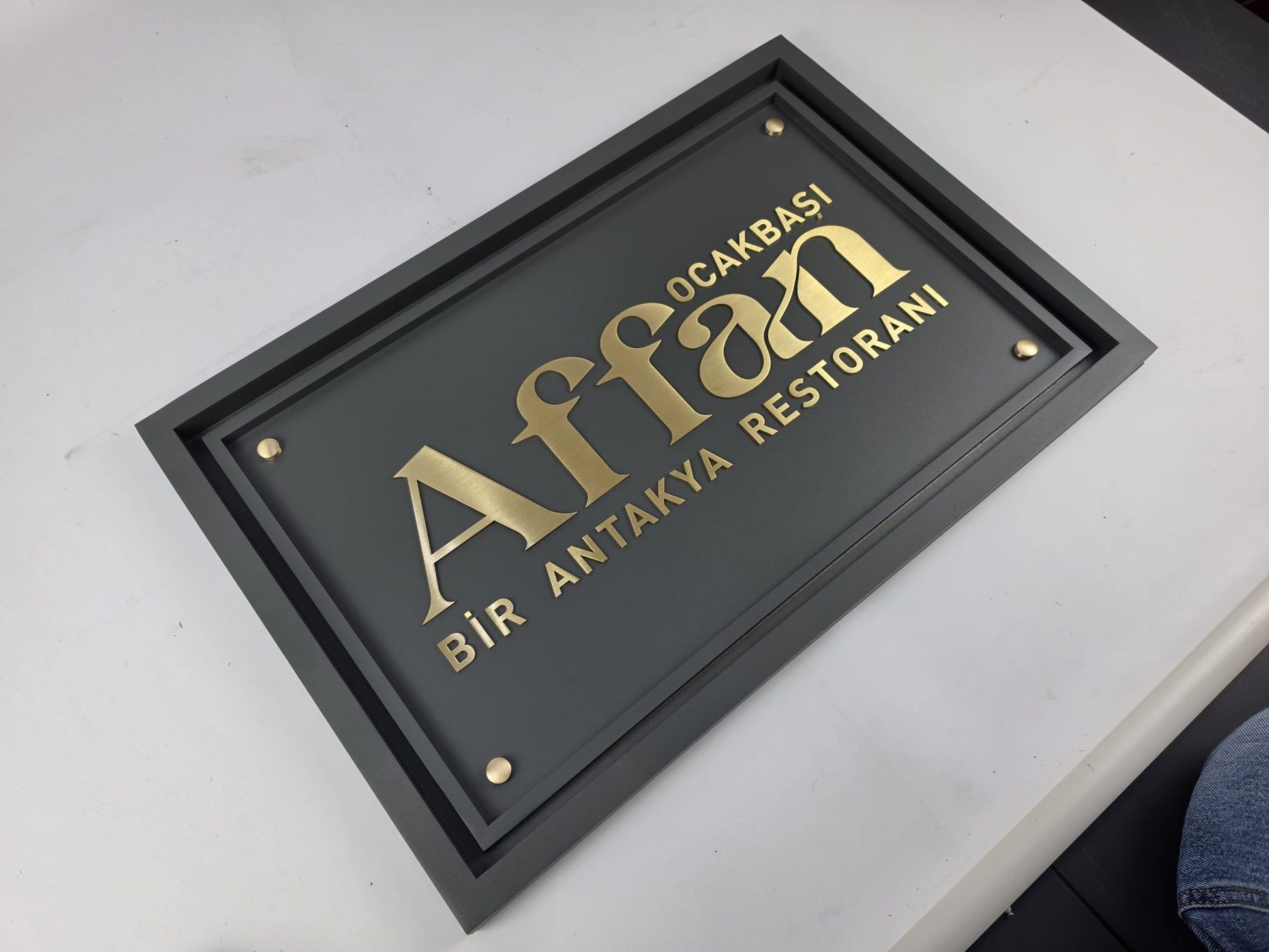 Çerçeveli pirinç harfli işletme tabelası modern restoran girişinde