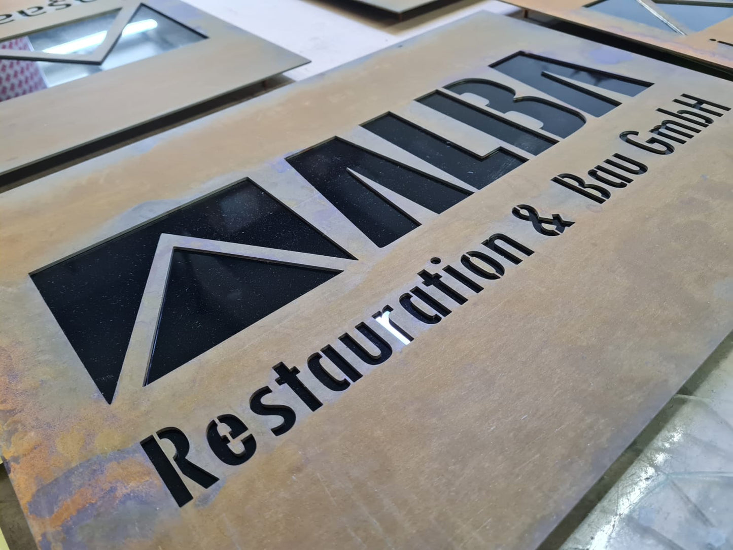 Corten tabela üzerindeki dekupe firma yazısı ve logo detayı