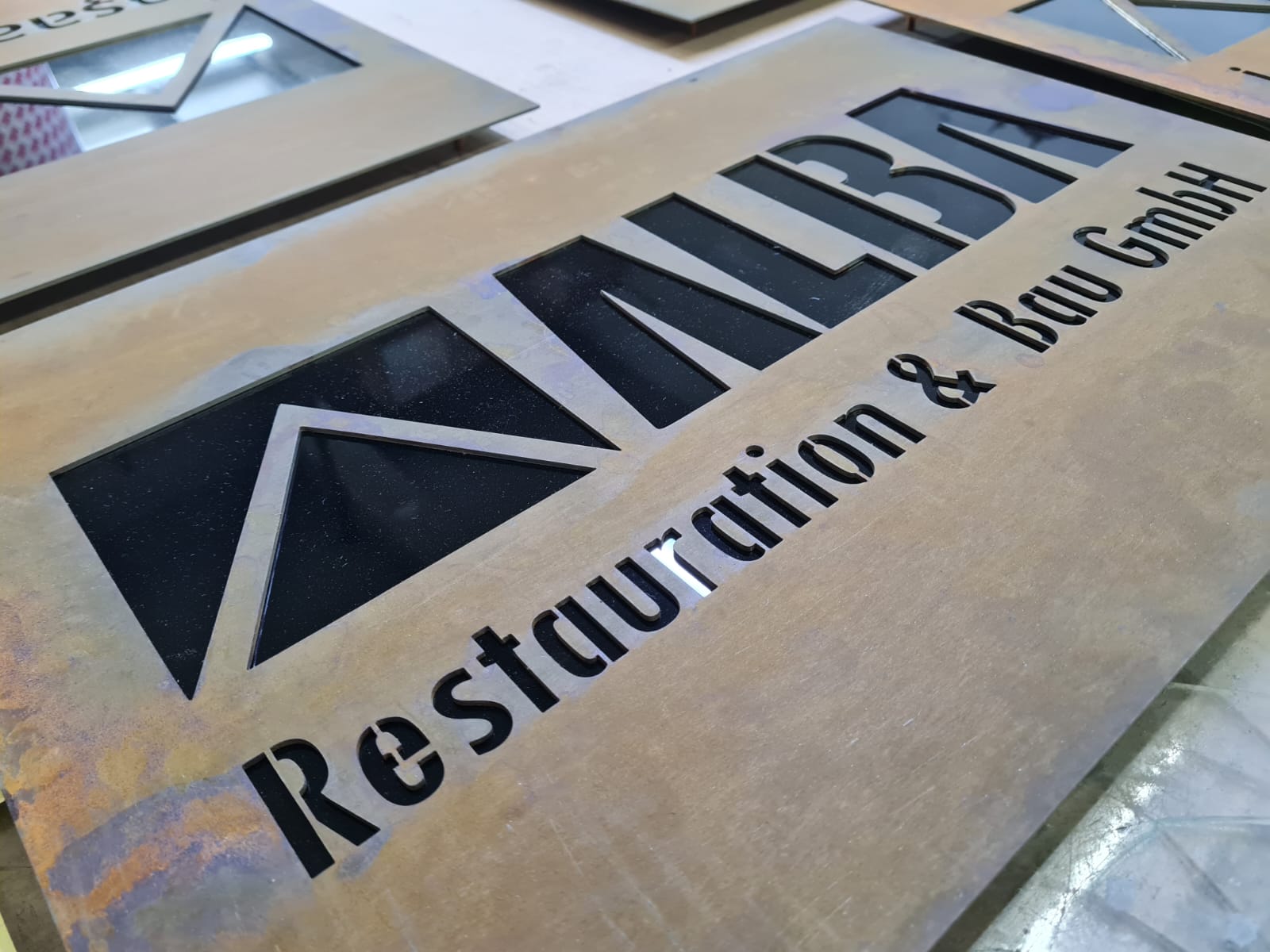 Corten tabela üzerindeki dekupe firma yazısı ve logo detayı