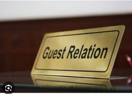 Gold renk paslanmaz çelik Guest Relation masa isimliği ve otel karşılama tabelası.