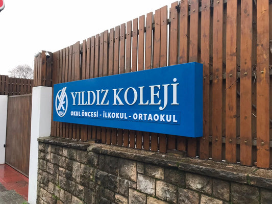 LED aydınlatmalı kurumsal giriş tabelası, modern işletme cephesinde kabartma harfli tasarım.