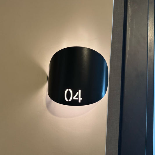 Arkadan LED aydınlatmalı kavisli otel oda numarası tabelası, modern koridorlar için şık kapı yönlendirme çözümü.