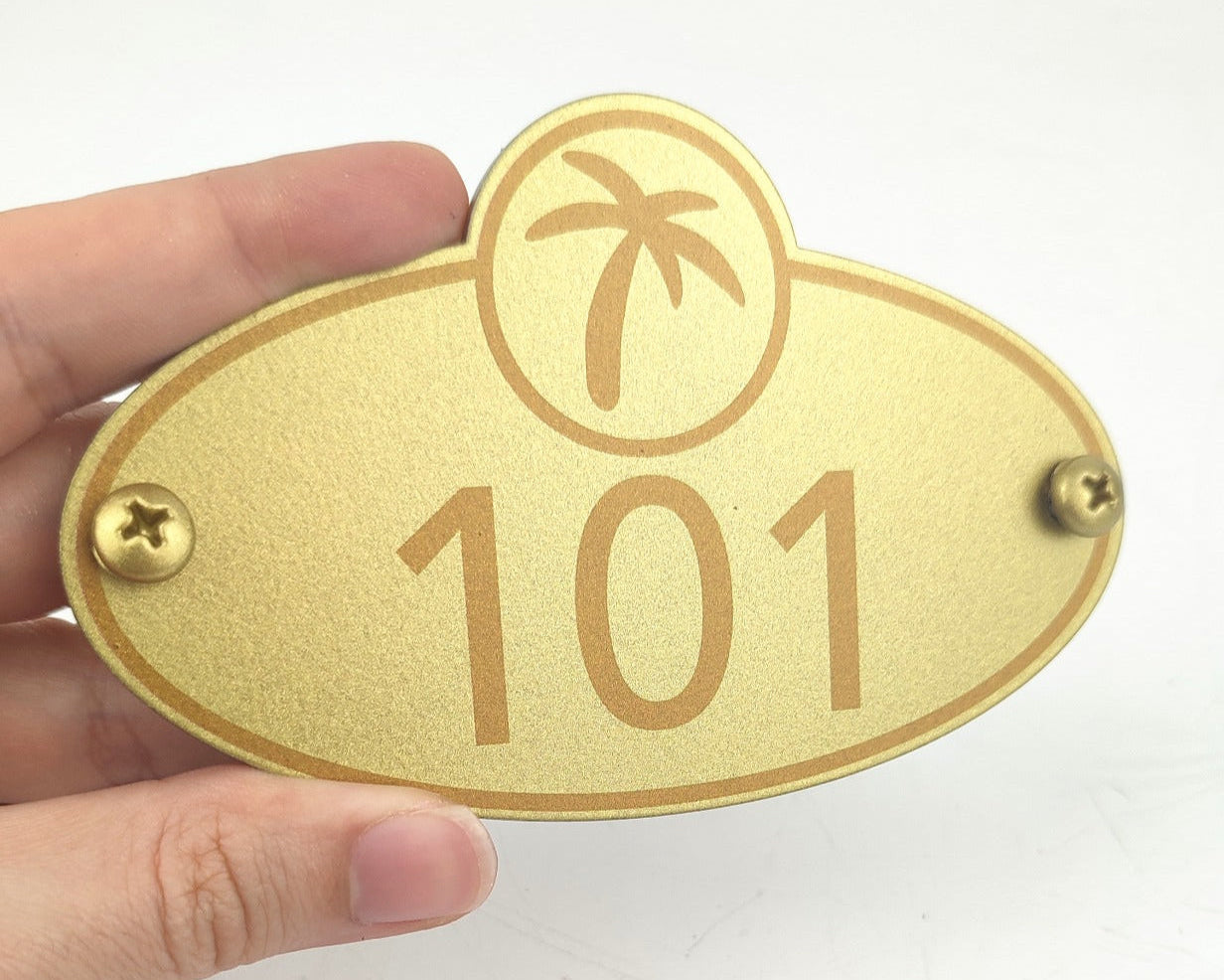 Gold renk metal oda numarası tabelaları ile modern otel yönlendirme sistemi.
