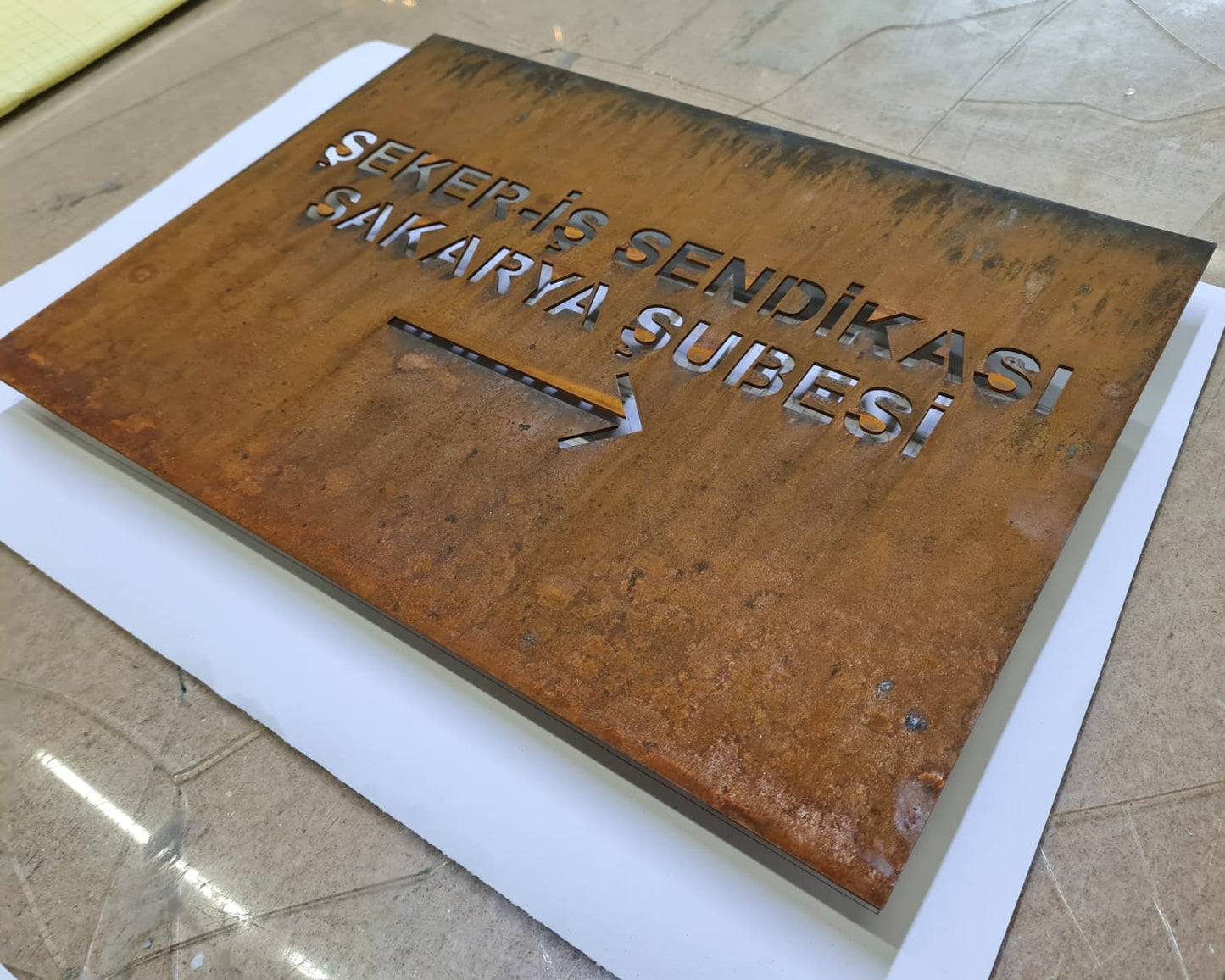 Karakteristik pas dokusu ve doğal yüzey görünümüne sahip corten tabela