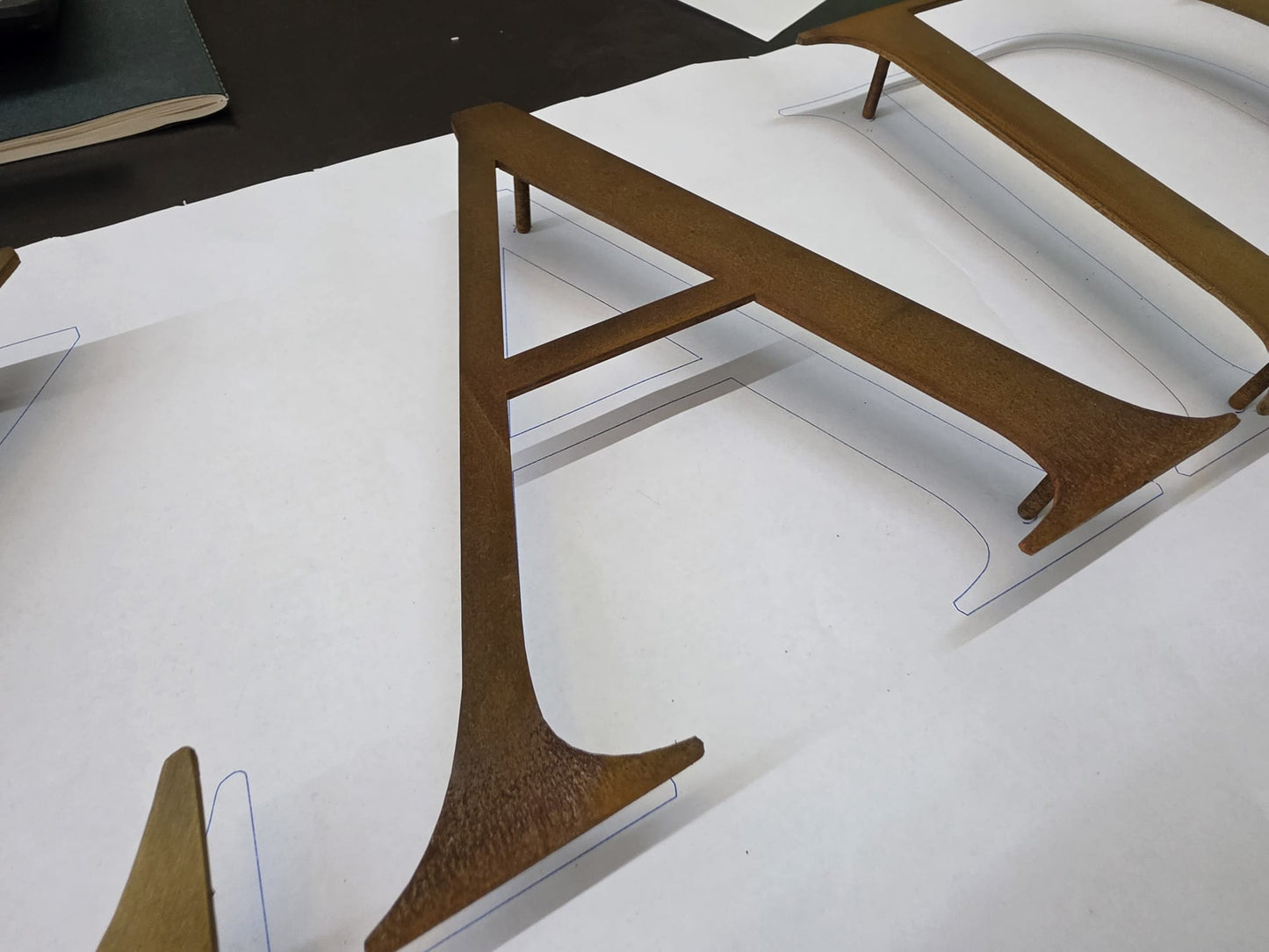 Corten metal harflerin duvara pimli montaj sistemini gösteren detay