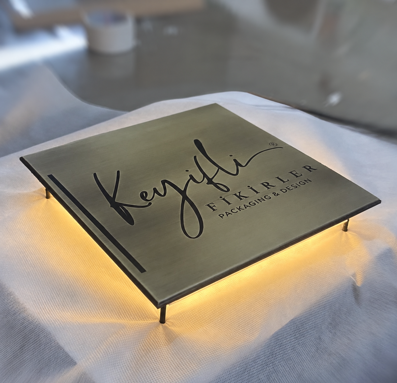 Pimli montaj sistemi ve arkadan aydınlatması bulunan metal logo duvar panosu