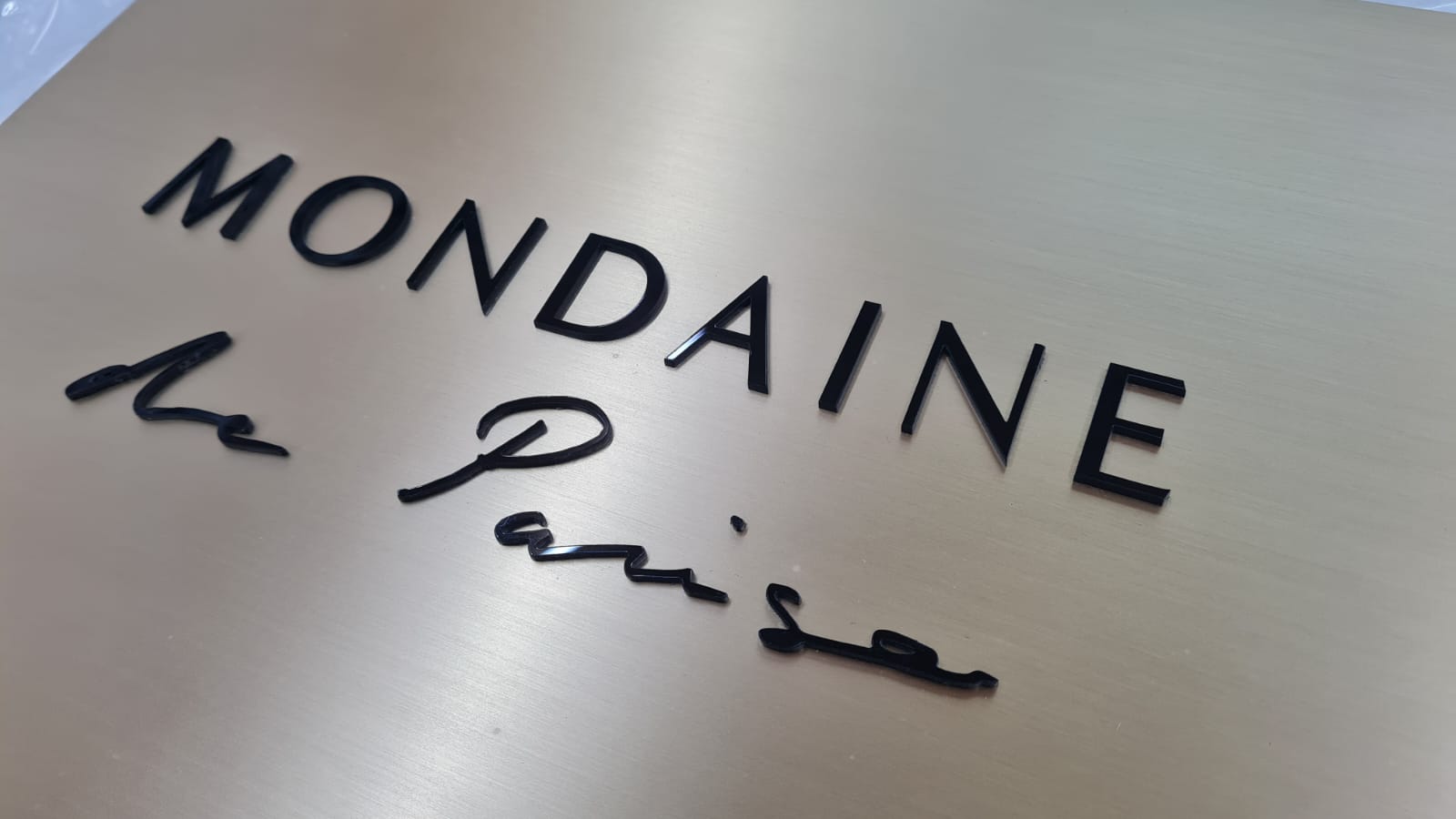 Mat pirinç zemin üzerinde üç boyutlu siyah pleksi harflerle üretilmiş zarif marka tabelası. Modern ve klasik mekanlara uyumludur.