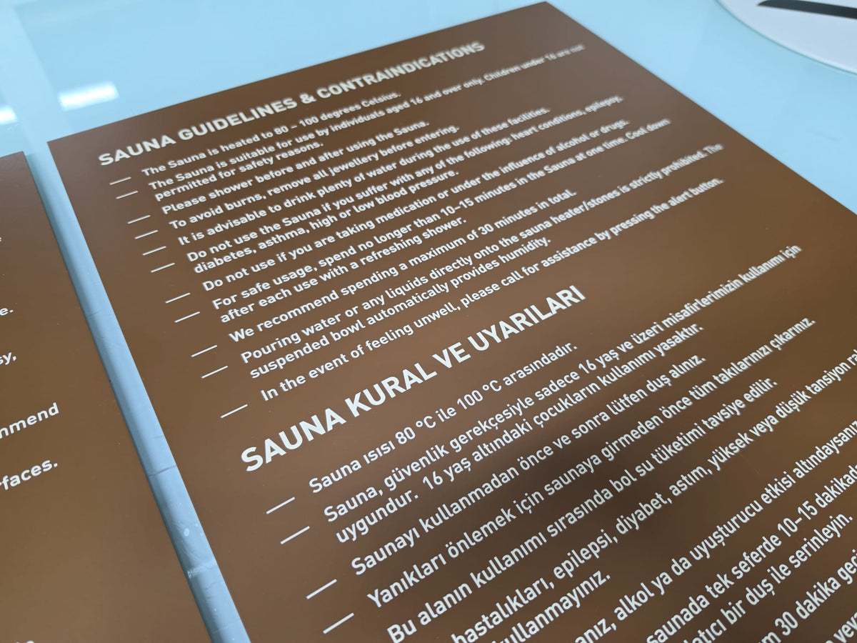 Sauna kullanımı öncesinde sağlık ve güvenlik uyarılarını gösteren metal pano
