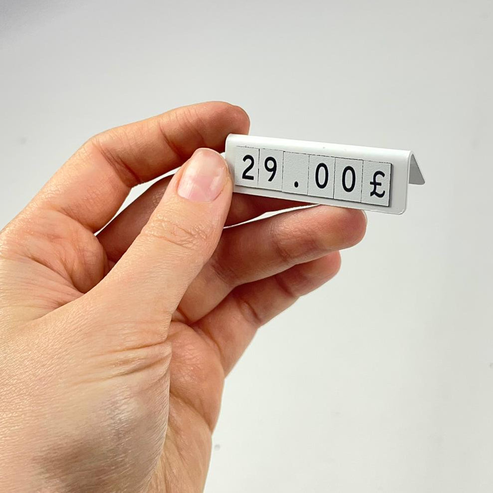 Showroom ürün masalarında kullanılan metal fiyat gösterge çözümü.