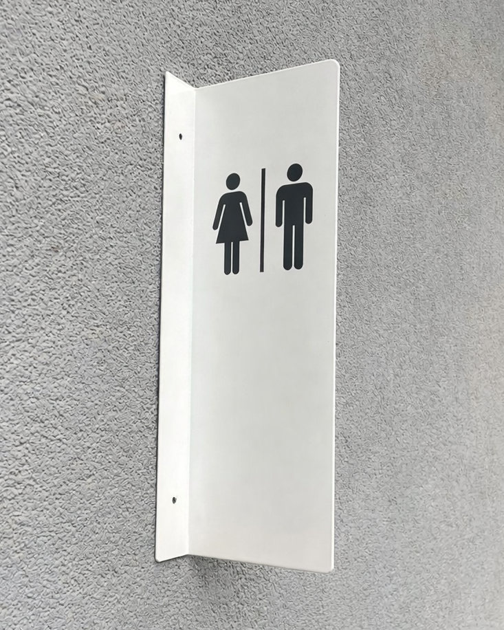 Duvara monte edilmiş beyaz metal erkek kadın WC tabelası, modern tasarımlı tuvalet yönlendirme levhası.